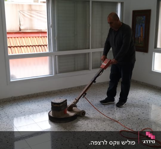 אדם מנקה רצפה עם מכונת פוליש חשמלית